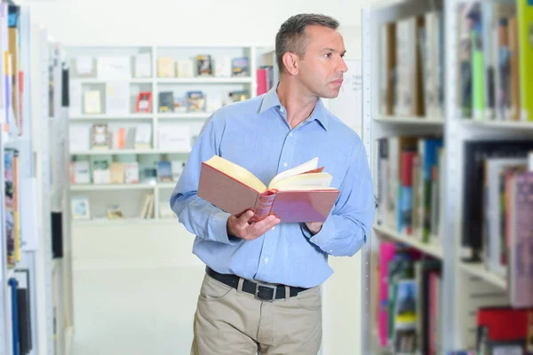 Homem Procurando Livro Prateleira Biblioteca — Fotografia de Stock