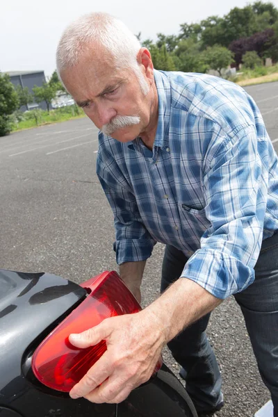 Gammal Man Installerar Bakljus Fordonet — Stockfoto