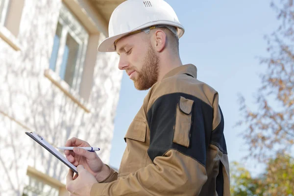 Aannemer Maken Van Aantekeningen Buiten Residentieel Gebouw — Stockfoto