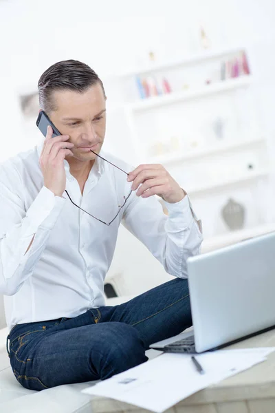 Man Met Een Laptop Een Telefoon Thuis — Stockfoto