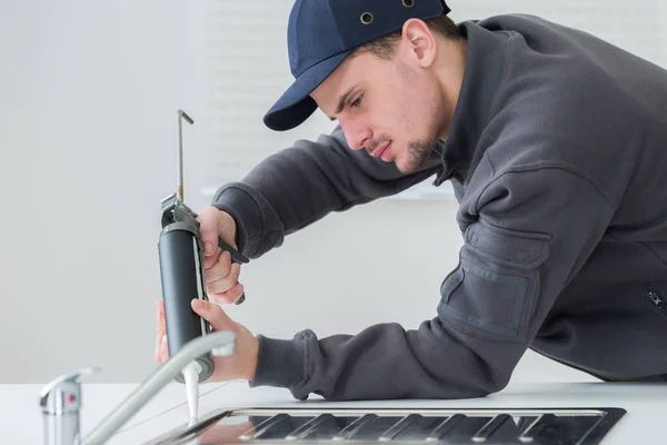 Focused Young Technician Sealing Sink Clients Kitchen — Stock Photo, Image