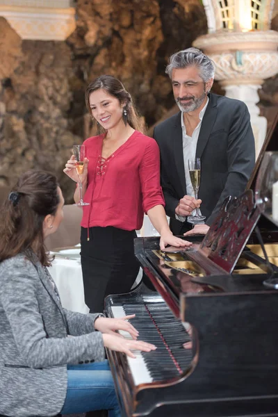 Mujer Tocando Piano Para Una Pareja —  Fotos de Stock