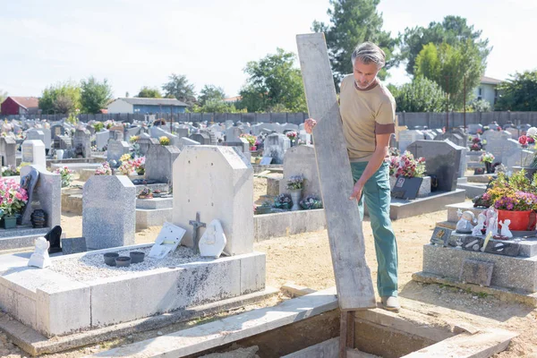 Άνδρας Ψάχνει Στο Τάφο Στο Νεκροταφείο — Φωτογραφία Αρχείου