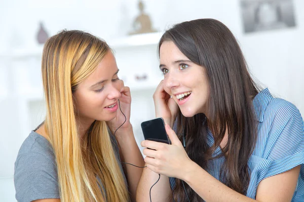 Zwei Schöne Mädchen Teilen Sich Kopfhörer Und Hören Musik — Stockfoto