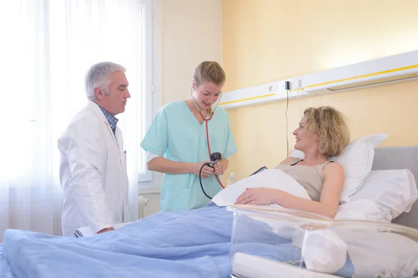 Enfermera Tomando Presión Arterial Del Paciente Siendo Supervisado Por Médico —  Fotos de Stock