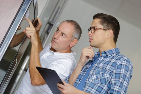 Dos Trabajadores Inspeccionando Ventanas Taller —  Fotos de Stock