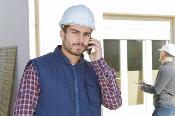 Genç Yakışıklı Mimar Bir Inşaat Alanında Cep Telefonu Kullanarak Denetleme — Stok fotoğraf