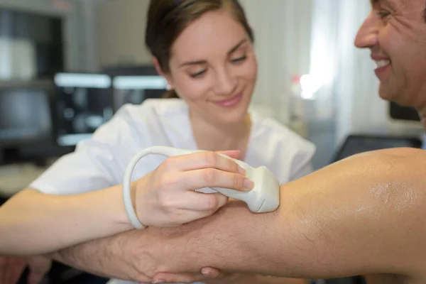 男性患者の受けている腕の超音波検査女性医師 — ストック写真