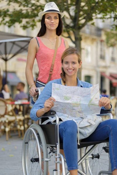 Zwei Freunde Besuchen Fremde Stadt Einer Sitzt Rollstuhl — Stockfoto