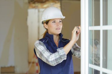 woman builder unscrews the fixing screws of the window handle clipart