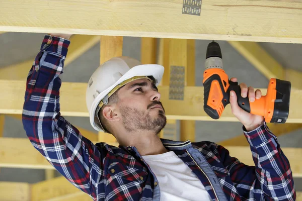 Ahşap ev matkap ile çalışan marangoz — Stok fotoğraf
