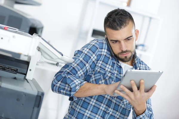 Hombre hablando en el PC mientras usa una tableta —  Fotos de Stock