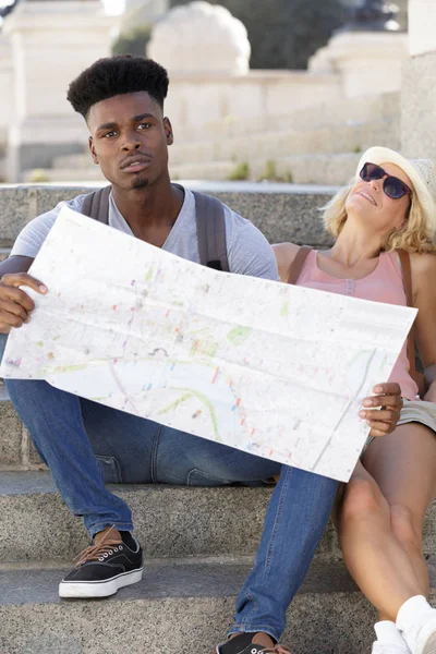 Lovely mixed couple with a map — Stock Photo, Image