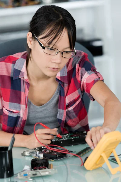 Mujer joven fijar componente de PC en el centro de servicio —  Fotos de Stock