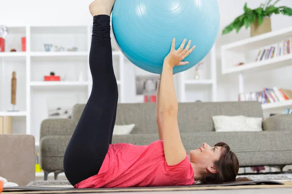 Facendo esercizi di gambe con palline da fitness sul pavimento — Foto Stock