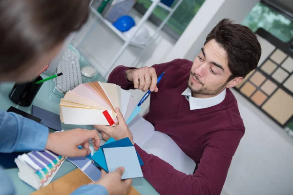 Interieur ontwerper toont kleur wiel aan de klant in zijn atelier — Stockfoto