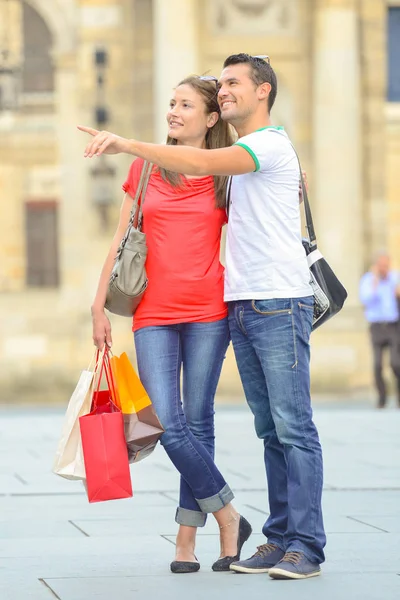 Man and woman outdoors with shopping bags — Stock Photo, Image