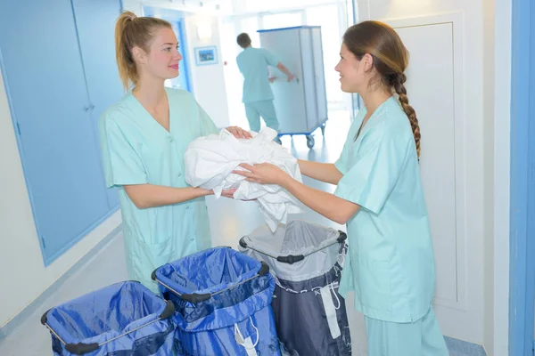 Trabajadores que preparan bolsas reales de ropa de hospital — Foto de Stock