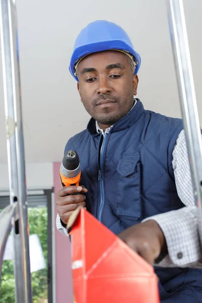 Мужчина-строитель с помощью беспроводной отвертки — стоковое фото