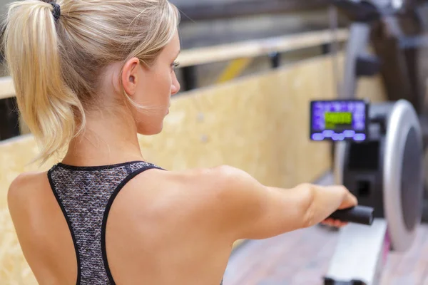 Mujer en máquina de remo — Foto de Stock