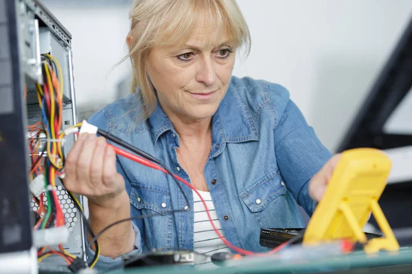 Mature woman testing a motherboard — Stock Photo, Image