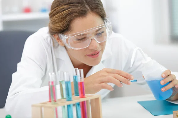 Student doing chemistry test with liquids and tubes — Stock Photo, Image