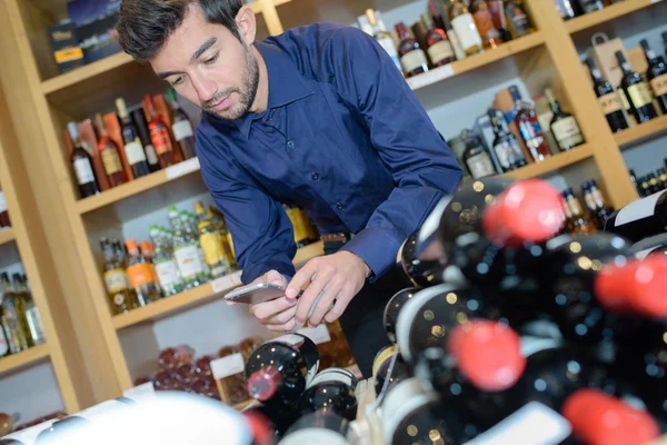 Man met smartphone scannen wijn fles — Stockfoto