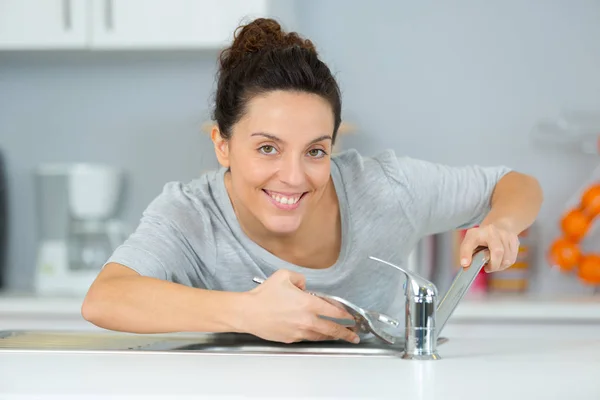 Female plumber finishing a sink installation — Stock Photo, Image