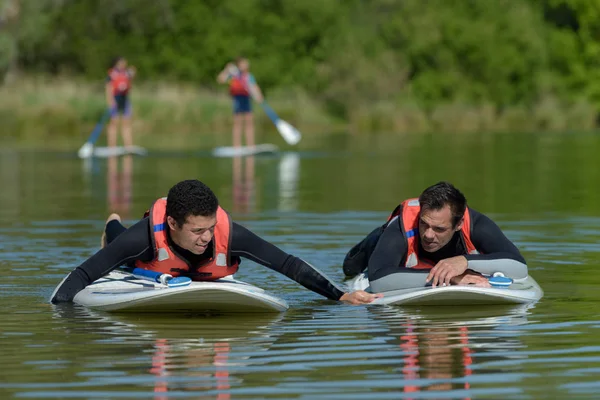 Two men paddle surfboards — Stock Photo, Image