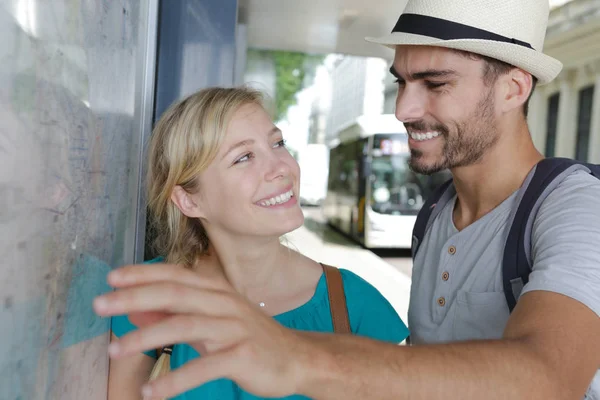 Happy tourists or travellers looking with happy expression the map — Stock Photo, Image