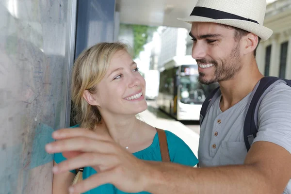 Turistas felices o viajeros que buscan con expresión feliz el mapa — Foto de Stock