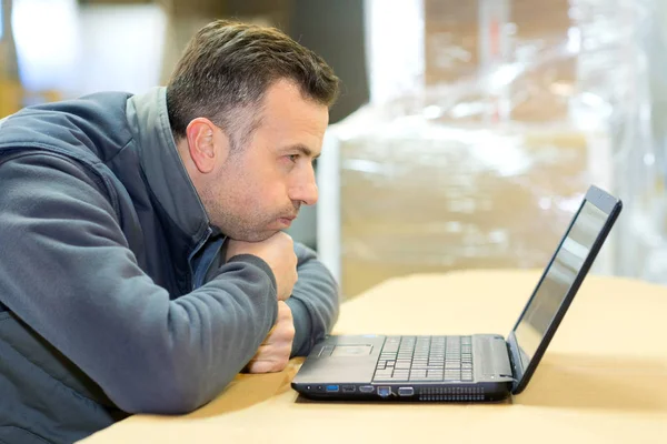 Fabrieks medewerker in charge van verpakking kijken naar laptop — Stockfoto