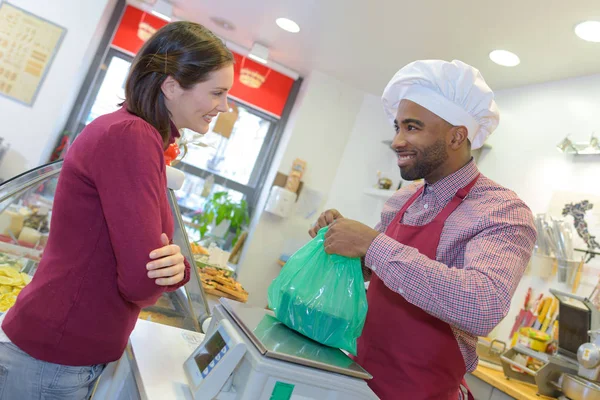 Winkelier geeft gebak aan vrouw — Stockfoto