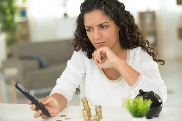 Žena počítající mince s kalkulačkou — Stock fotografie