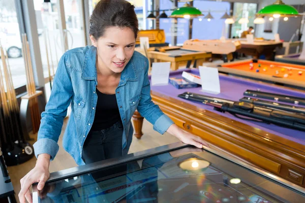 Frau spielt Arcade-Spiel in Snookerhalle — Stockfoto