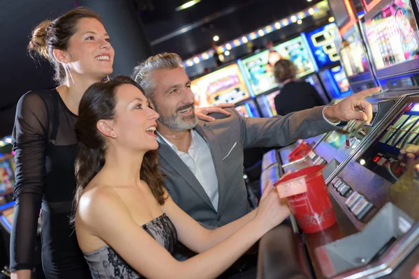 Группа друзей, играющих на игровых автоматах — стоковое фото