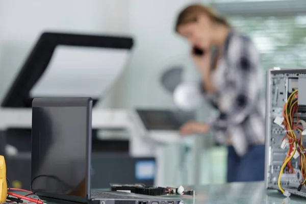 Telefondaki genç teknisyen kadın yeni yazıcı kuruyor. — Stok fotoğraf