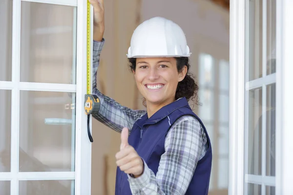 Boldog női munkás intézkedés az ablakon — Stock Fotó
