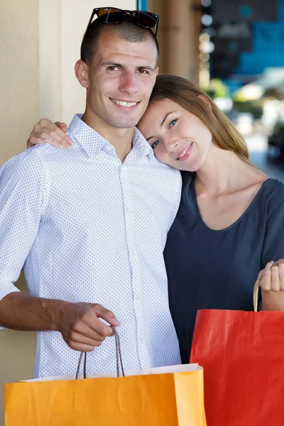 幸せな若いカップルがショッピング モールで買い物袋 — ストック写真