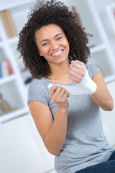 Lycklig ung kvinna att ta bort ett bandage hemma — Stockfoto