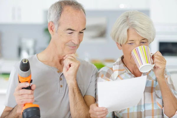 Coppia anziana guardando il piano di nuova cucina — Foto Stock