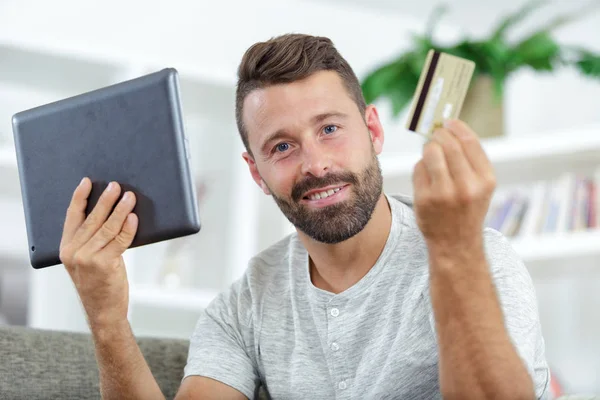Retrato de hombre de negocios alegre con tarjeta de crédito y tableta —  Fotos de Stock
