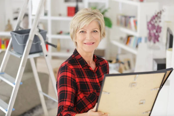 Volwassen vrouw opknoping foto thuis — Stockfoto