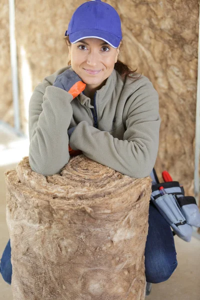 Constructora femenina posando junto a un rollo de lana aislante —  Fotos de Stock