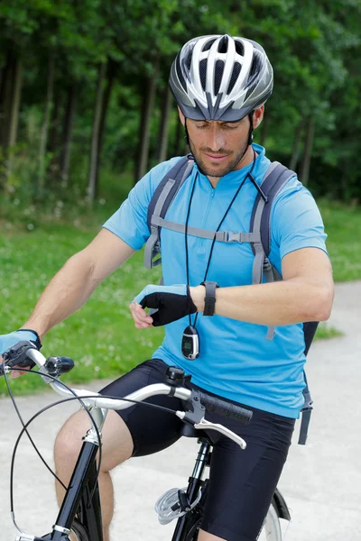 Chico en una bicicleta de montaña utiliza un wacth ciclismo — Foto de Stock