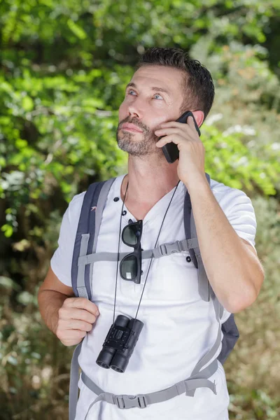 Excursionista masculino usando smartphone en el campo —  Fotos de Stock