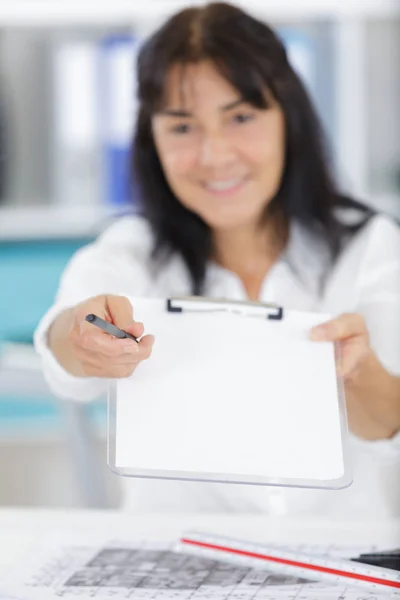 Donna mostrando un clipboard — Stockfoto