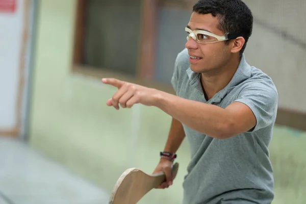 Jovem homem jogar pelota vestindo proteção ocular — Fotografia de Stock
