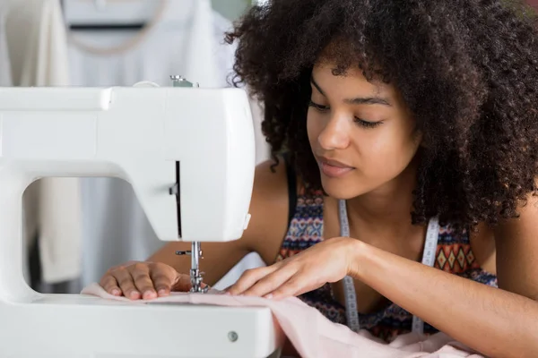 Close up de jovem costureira usando máquina de costura — Fotografia de Stock