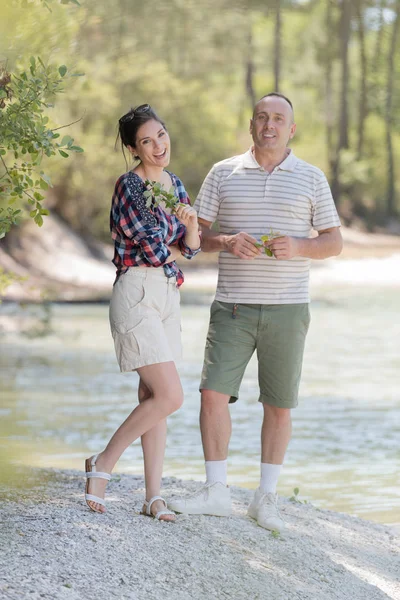 Adultes posant à côté de la rivière — Photo